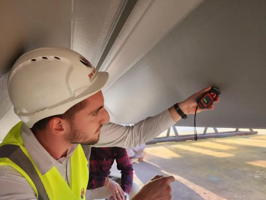NDT testing under bridge structure — engineer using testing equipment