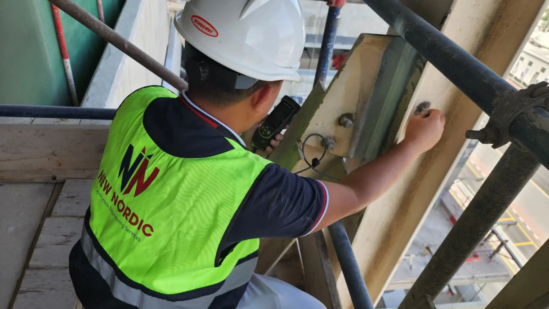 Engineer performing corrosion testing on structural steel with NDT equipment