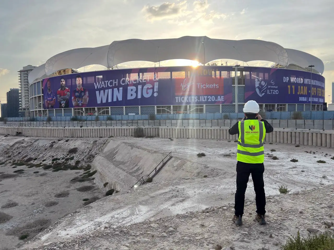 New Nordic engineer surveying a stadium structure in Dubai at sunset